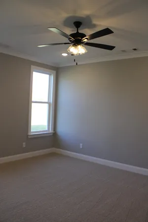 an empty room with a window and a fan