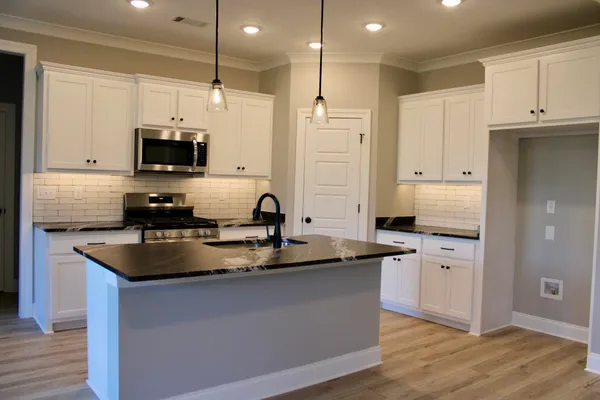 a kitchen with stainless steel appliances granite countertop a sink a stove and a refrigerator