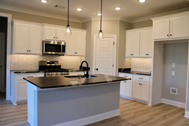 a kitchen with stainless steel appliances granite countertop a sink a stove and a refrigerator