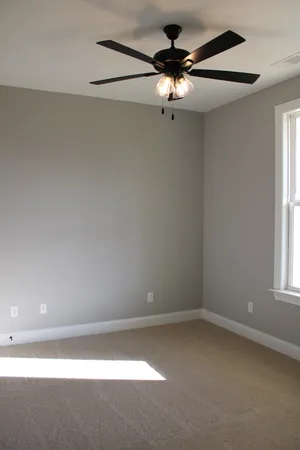 an empty room with a window and a fan
