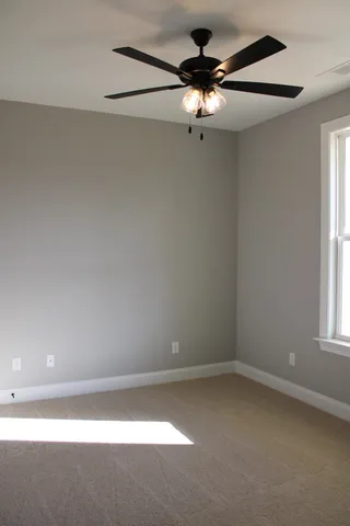 an empty room with a window and a fan