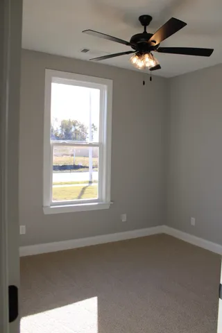 a view of a livingroom with a ceiling fan and window