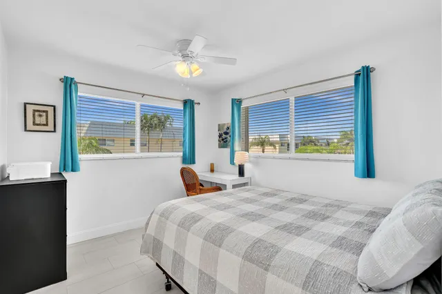 an aerial view of a tennis ground and a cars park side of the road