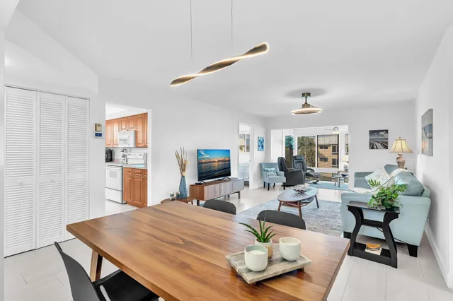 a kitchen with stainless steel appliances a table chairs and a refrigerator