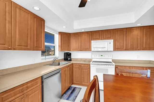 a kitchen with stainless steel appliances granite countertop a refrigerator a sink a stove and a refrigerator