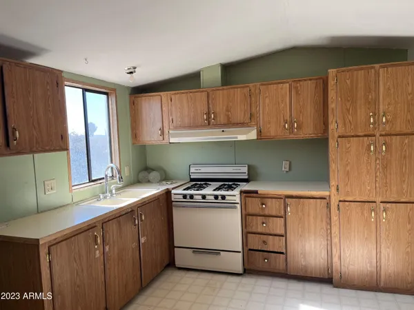 a kitchen with a stove sink and cabinets