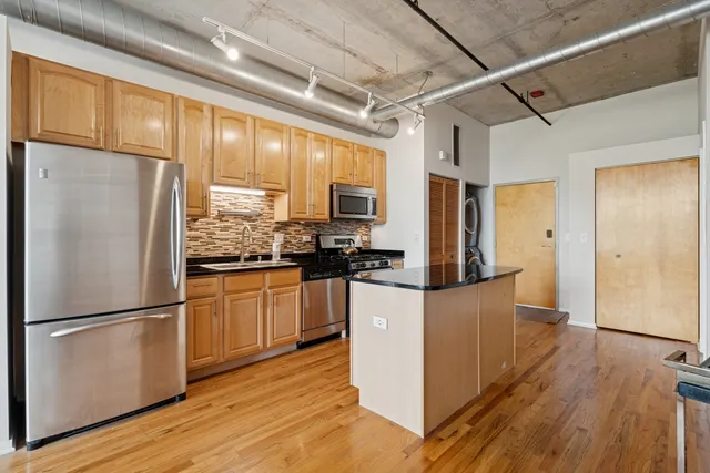 a kitchen with stainless steel appliances a refrigerator stove microwave and cabinets