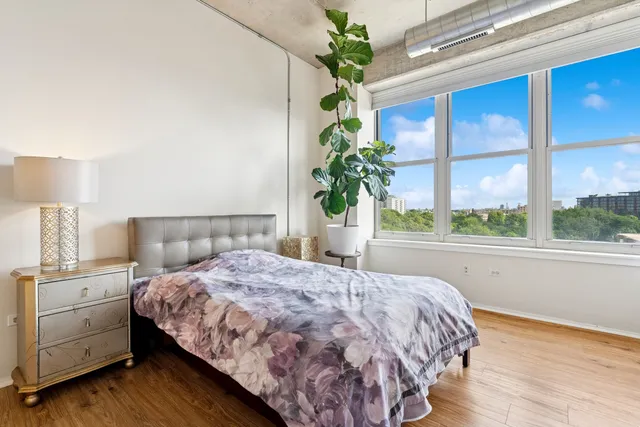 a bedroom with a bed potted plant and a window