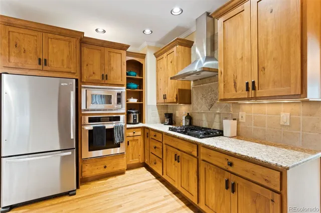 a kitchen with stainless steel appliances granite countertop a refrigerator a stove and a sink