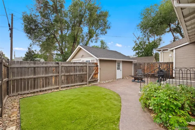 a view of a chair and table in backyard of the house