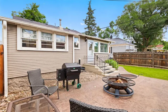 a view of a backyard with furniture and garden