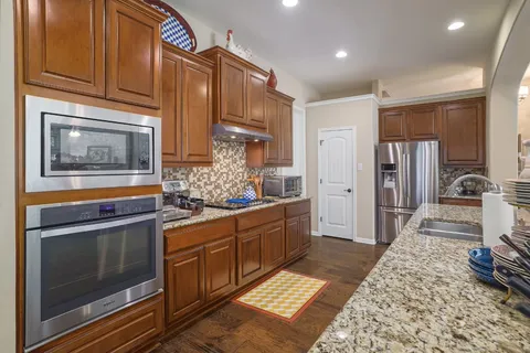 a large kitchen with stainless steel appliances granite countertop a stove and cabinets