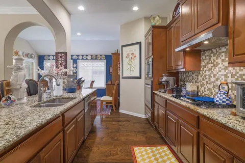 a kitchen with stainless steel appliances granite countertop sink stove and cabinets
