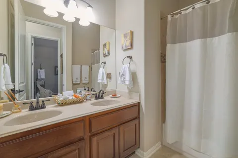 a bathroom with a double vanity sink and a mirror