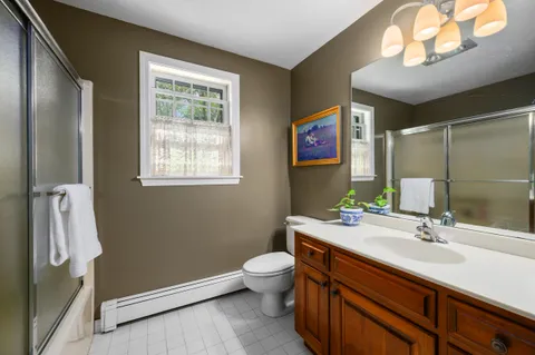 a bathroom with a sink a toilet and a mirror
