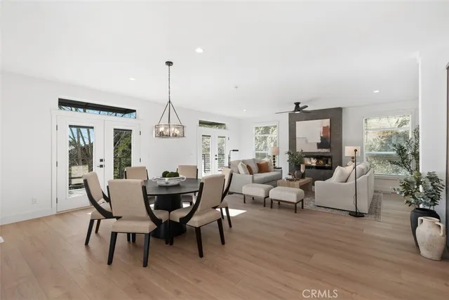 a living room with furniture kitchen view and a chandelier