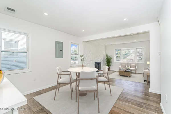 a dining room with stainless steel appliances kitchen island granite countertop a dining table chairs and view living room
