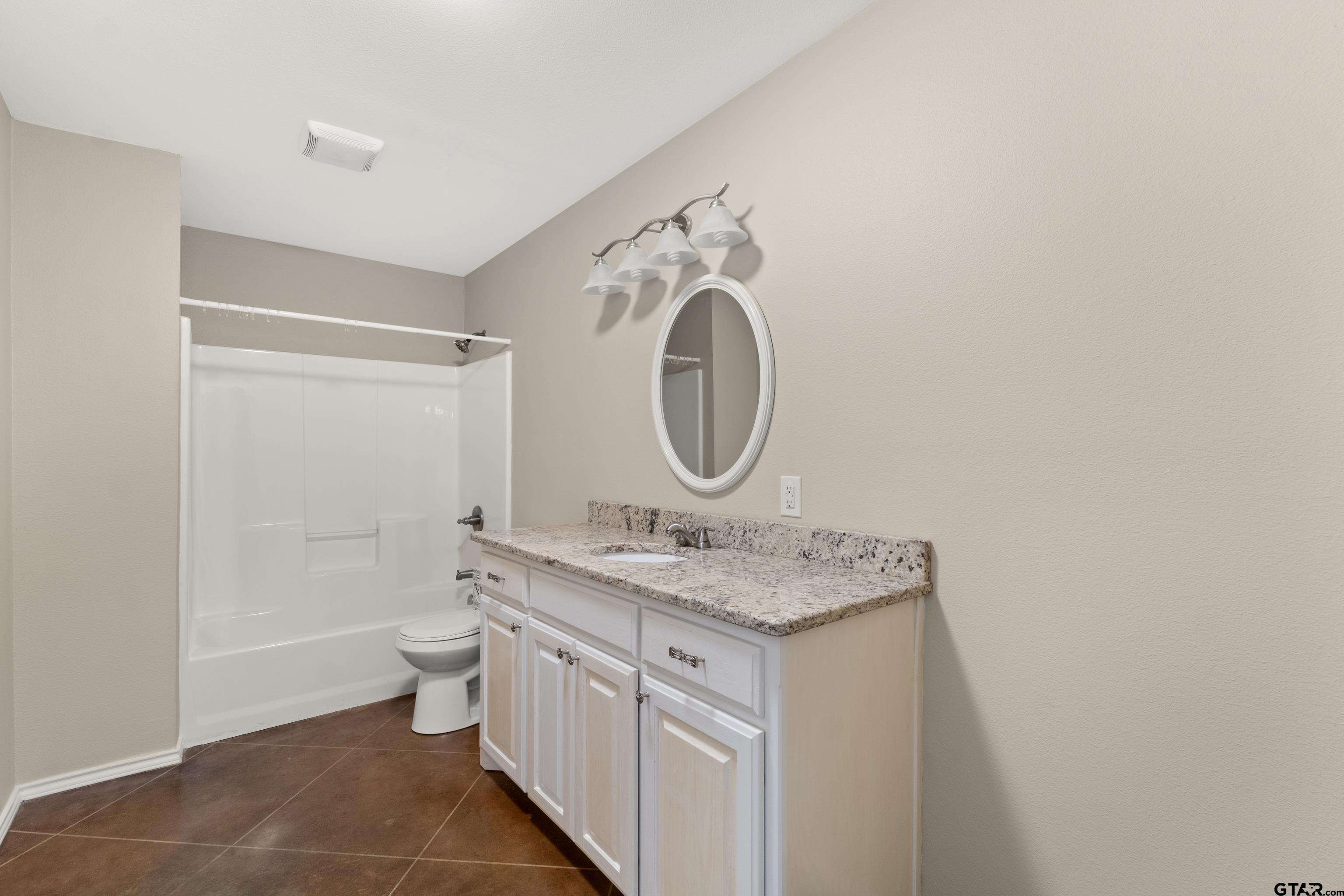 672 County Road 4960 Pittsburg, TX 75686 - Photo 17 of 26 a bathroom with a granite countertop sink toilet and a mirror