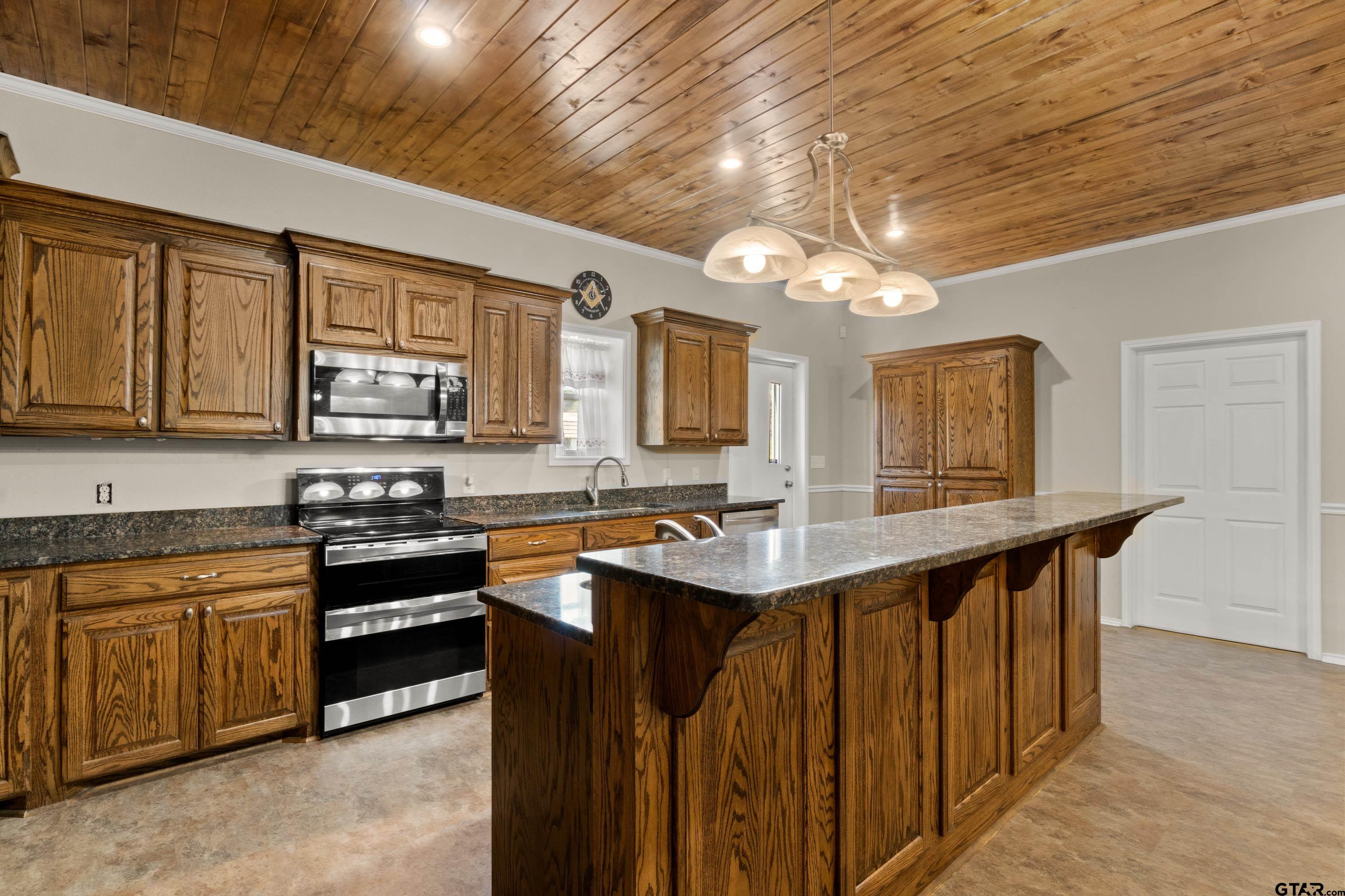 672 County Road 4960 Pittsburg, TX 75686 - Photo 9 of 26 a kitchen with stainless steel appliances granite countertop a sink a stove top oven a counter space and cabinets