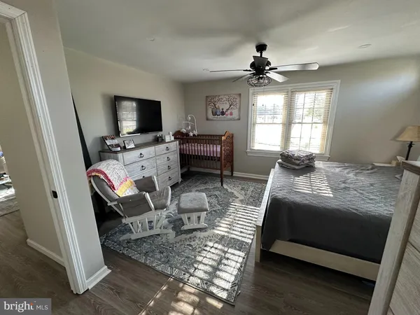 a bedroom with a bed a window and a flat screen television