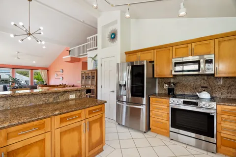 a kitchen with stainless steel appliances granite countertop a stove a sink and a microwave