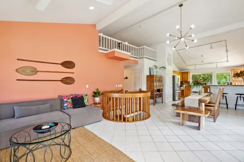 a living room with patio furniture and a chandelier