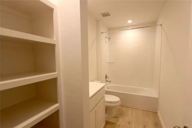 a bathroom with a granite countertop sink a toilet and shower