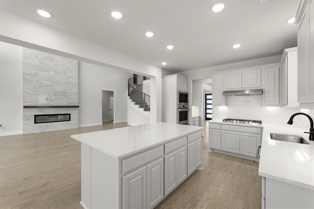 4213 Bellview Way Celina, TX 75009 - Photo 9 of 29 a kitchen that has a lot of white cabinets and stainless steel appliances