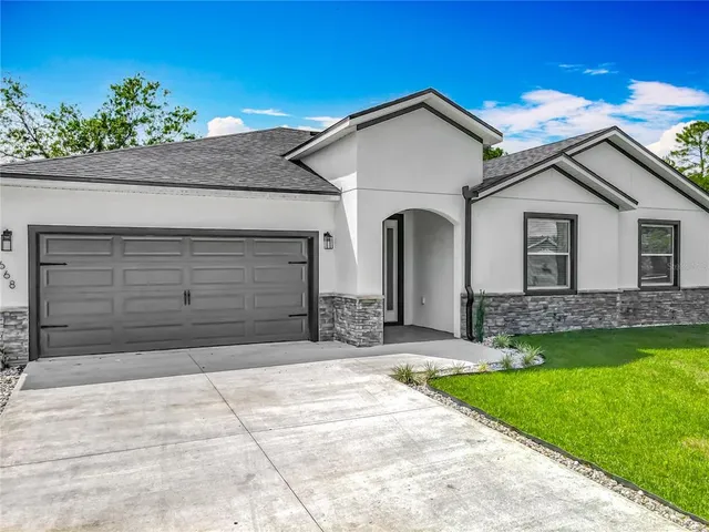 a front view of a house with a yard and garage