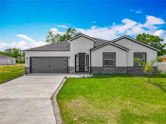 a front view of a house with a garden and yard
