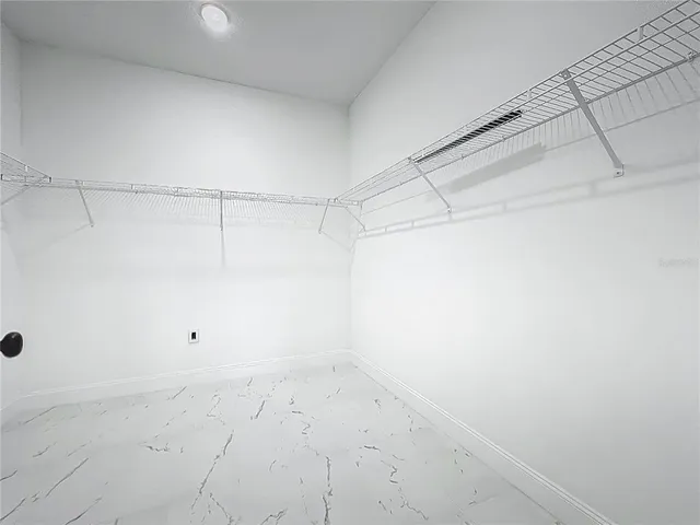 a view of a garage with storage and a fan