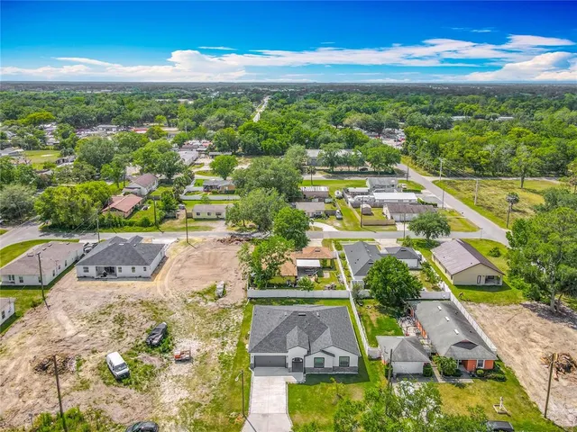 an aerial view of residential houses with outdoor space and street view