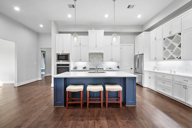 a kitchen with granite countertop a table chairs stove a refrigerator and cabinets