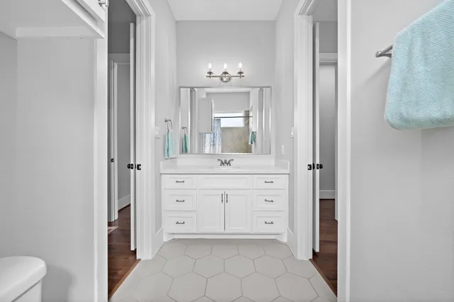 a bathroom with a sink a toilet and mirror