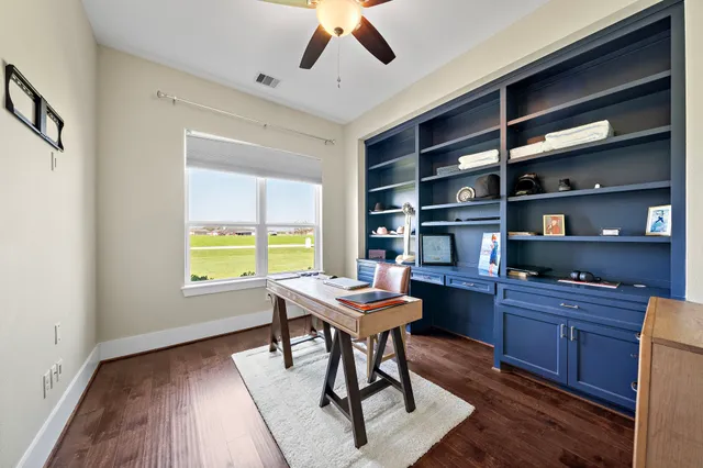 a view of a workspace with furniture and a window