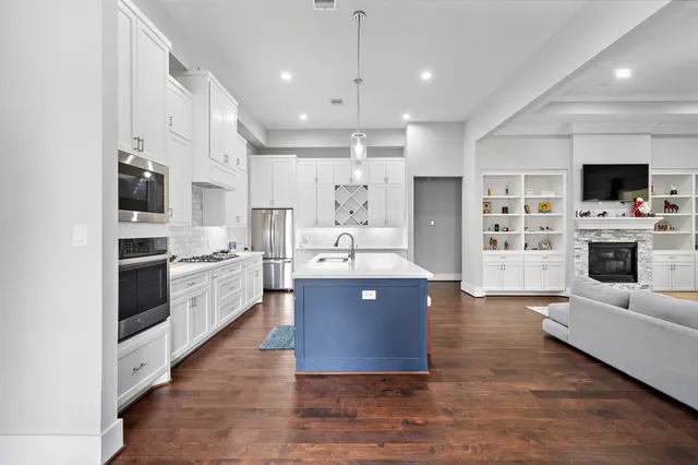 a large kitchen with stainless steel appliances and a large counter top