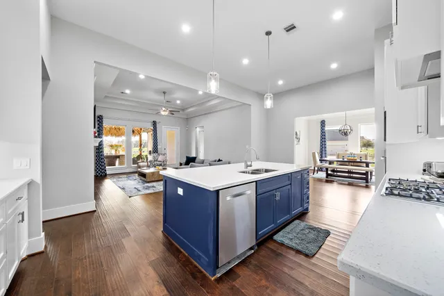 a large kitchen with stainless steel appliances granite countertop a large stove a refrigerator and a fireplace with wooden floor