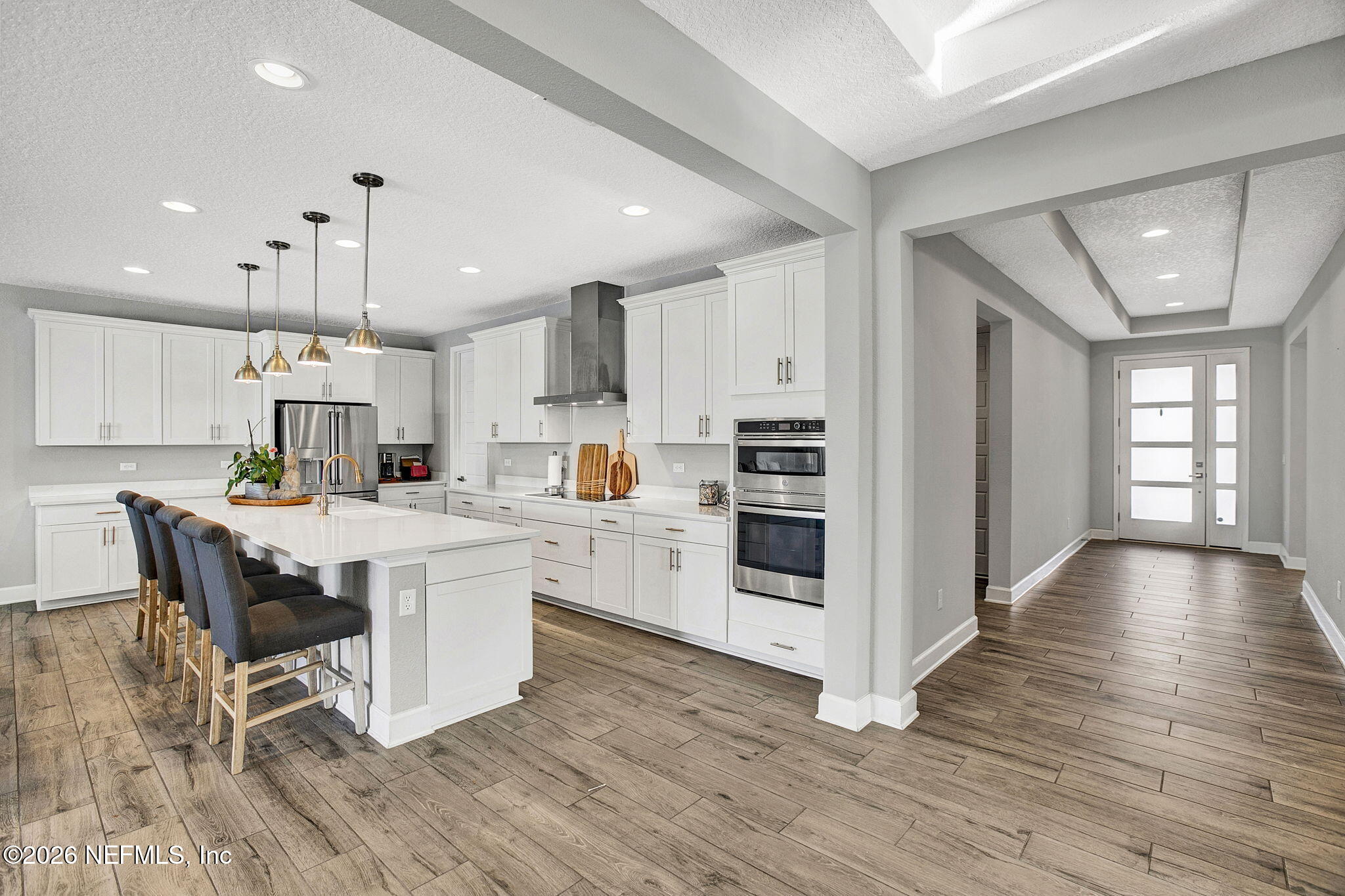 85401 Fall River Parkway Fernandina Beach, FL 32034 - Photo 3 of 38 a kitchen with stainless steel appliances a dining table chairs stove and white cabinets