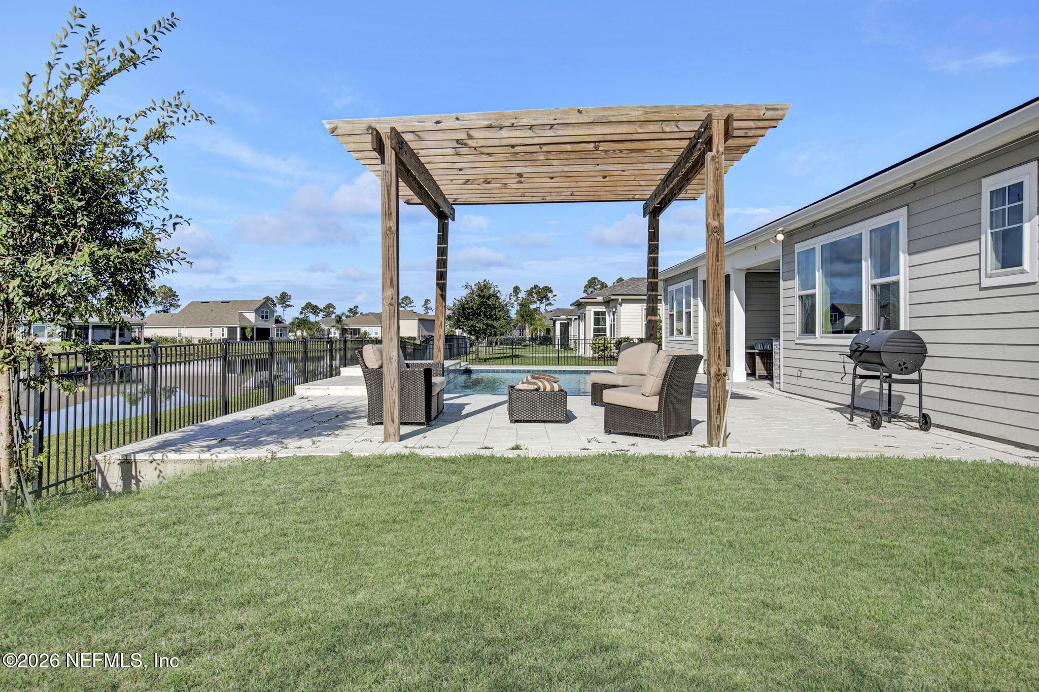 85401 Fall River Parkway Fernandina Beach, FL 32034 - Photo 34 of 38 a view of a patio with table and chairs potted plants and a palm tree