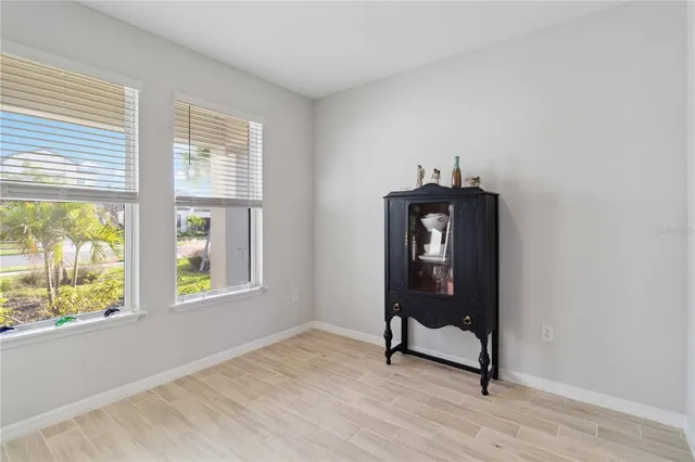 a view of a hallway with wooden floor and a bathroom