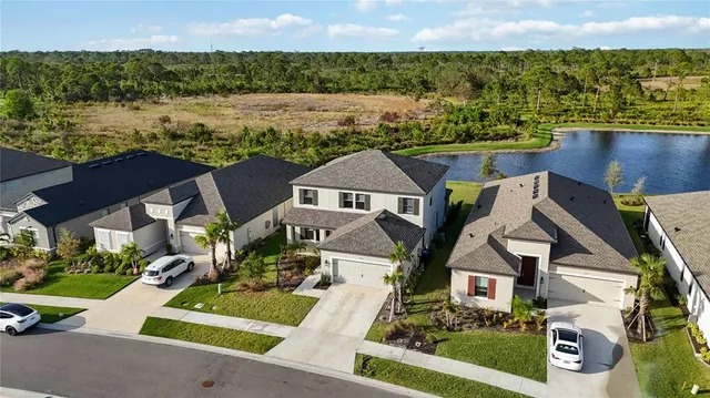 a front view of a house with a yard and lake view