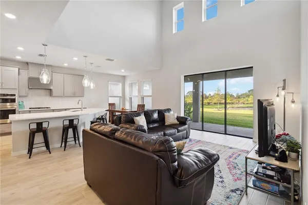 a living room with furniture and a view of kitchen
