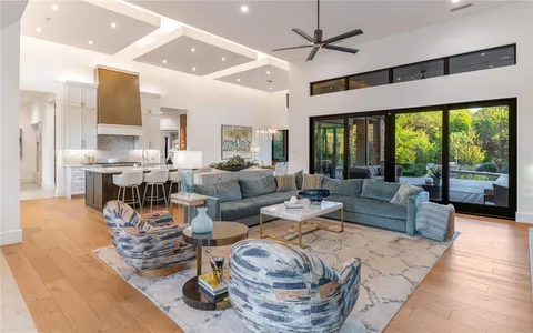 a living room with fireplace furniture and a large window