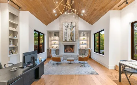 a living room with furniture a fireplace and next to windows