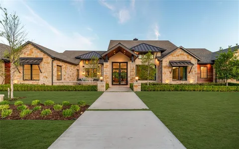 a front view of a house with a garden and yard