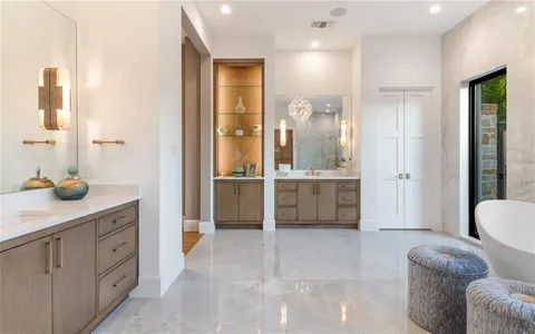 a spacious bathroom with a shower a sink and a mirror
