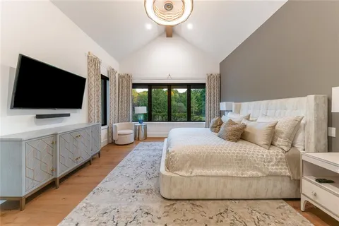 a spacious bedroom with a large bed and a flat screen tv