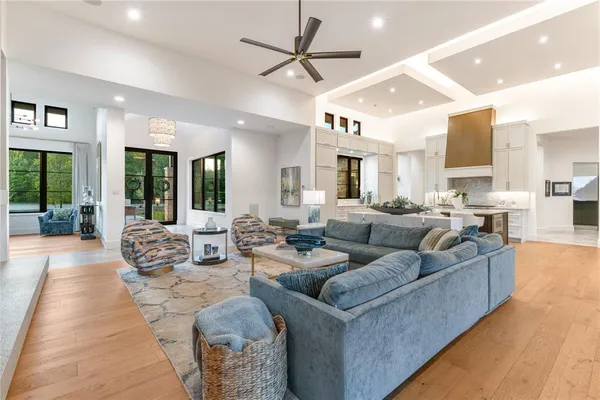 a living room with furniture kitchen view and a large window