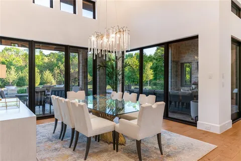 a view of a dining room with furniture large windows and wooden floor