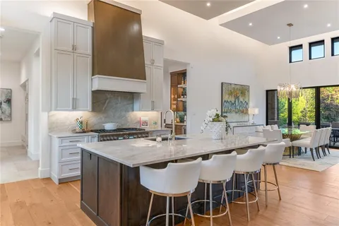 a kitchen with stainless steel appliances granite countertop a stove a sink a microwave and a dining table